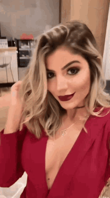 a woman in a red dress has a choker around her neck and red lipstick on her lips