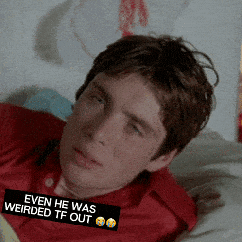 a man in a red shirt is laying on a bed with a sticker that says even he was weirded tf out