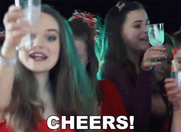 a woman is holding a glass of wine and the word cheers is on the screen