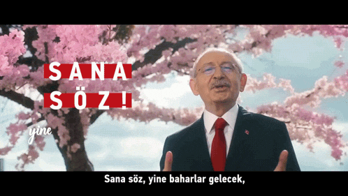 a man in a suit and tie stands in front of a cherry blossom tree with the words sana söz written above him