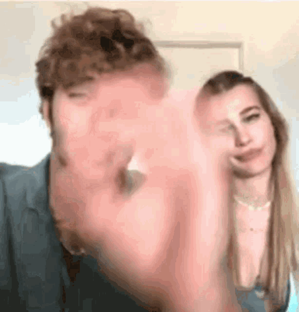 a man and a woman are giving each other a high five in a room .