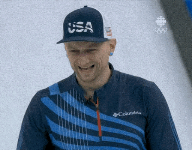 a man wearing a usa hat and a columbia jacket smiles