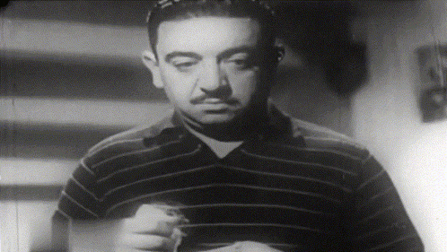 a man with a mustache is wearing a striped shirt in a black and white photo