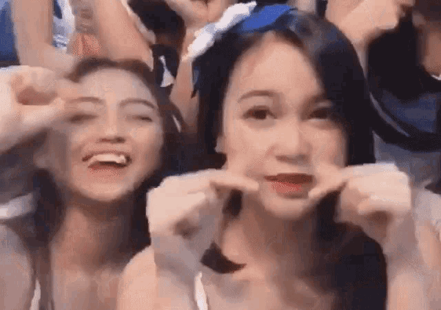 a group of young women are making funny faces at a concert .