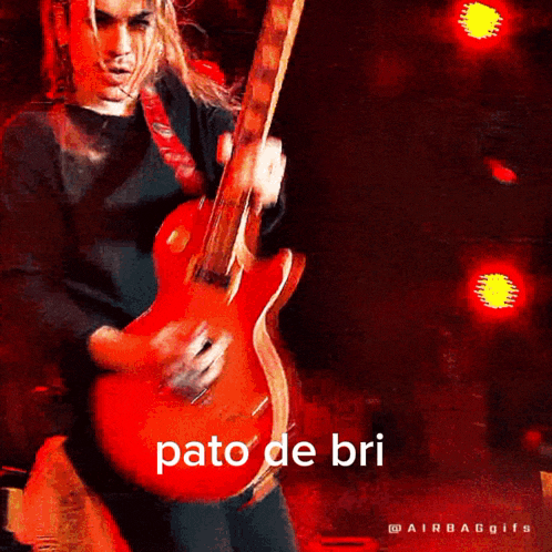 a man playing a red guitar with pato de bri written on the bottom right