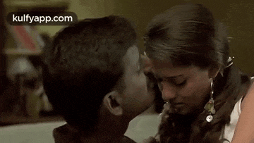a man is kissing a woman on the forehead in a movie .