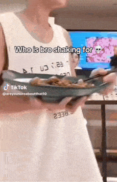 a man in a white tank top is holding a plate of food with chopsticks and the caption who is bro shaking for .