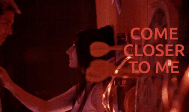 a blurred image of a man and woman with the words come closer to me in red