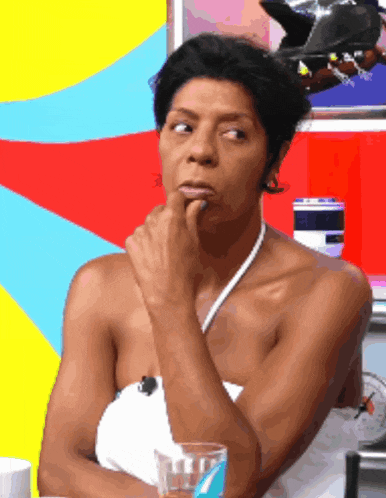 a woman in a white top holds her finger to her mouth