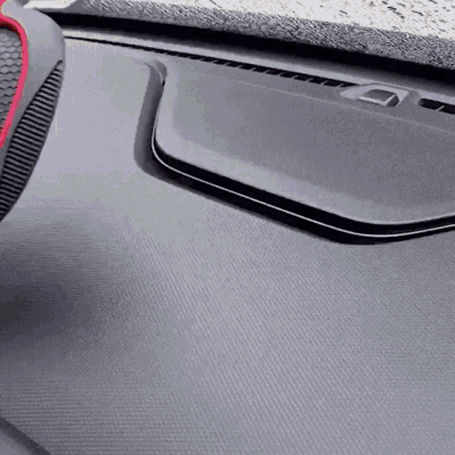 a close up of the dashboard of a car with a red rim