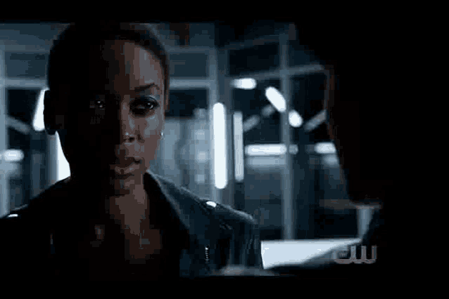 a man and a woman are standing next to each other in a dark room . the woman has a glowing face .