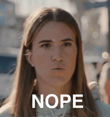 a woman with long hair is making a funny face with the word nope written in front of her .