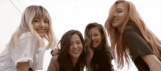 a group of young women are posing for a picture together and smiling .