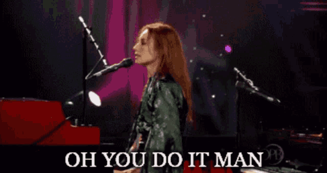 a woman singing into a microphone with the words oh you do it man