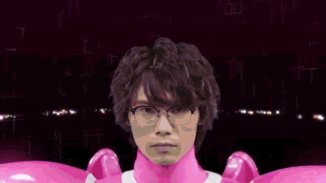 a man with glasses is surrounded by pink light