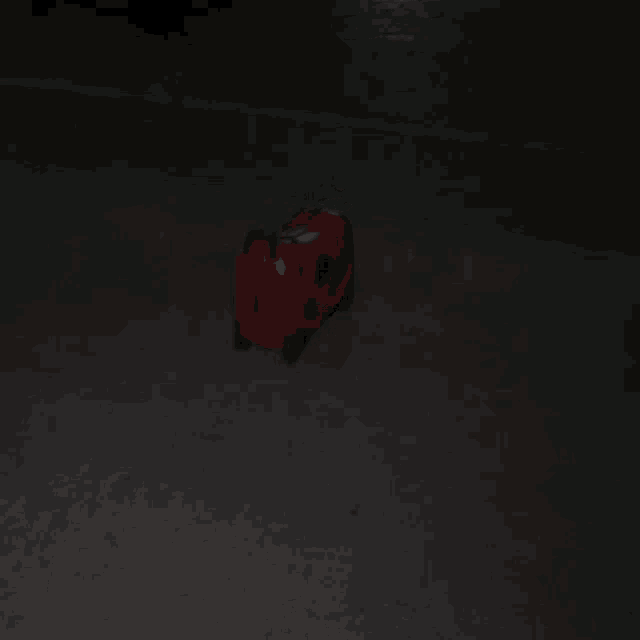 a red suitcase is sitting on a dark floor