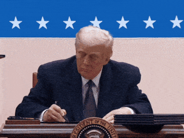 the president of the united states is sitting at a desk
