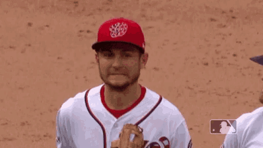 a man wearing a washington nationals baseball uniform is smiling