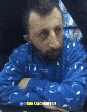 a man in a blue sweater with headphones on it