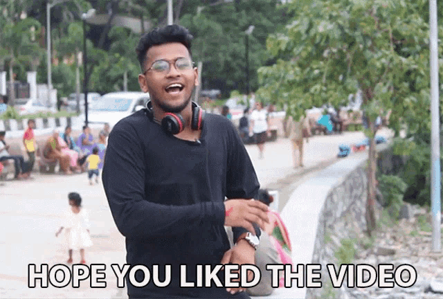 a man wearing headphones and glasses is laughing with the words hope you liked the video below him