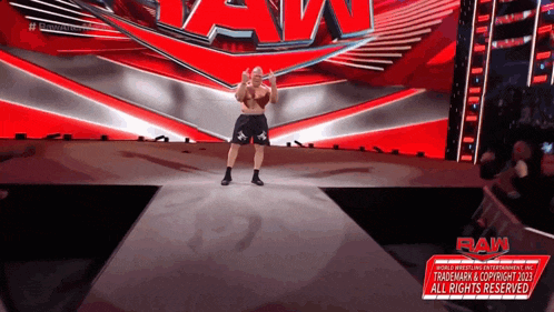 a man is standing on a stage with a sign that says raw