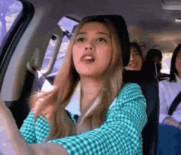 a woman in a plaid shirt is driving a car with other people
