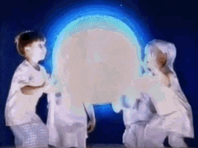 a group of children are playing with a glowing object in the dark