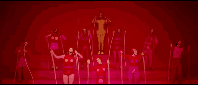 a group of people are holding ropes in their hands in a red room