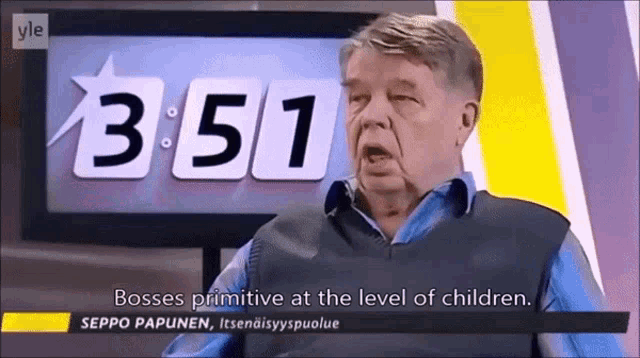 a man in a blue shirt is sitting in front of a clock that says 3:41