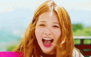 a woman with red hair is laughing with her mouth open and her tongue sticking out .