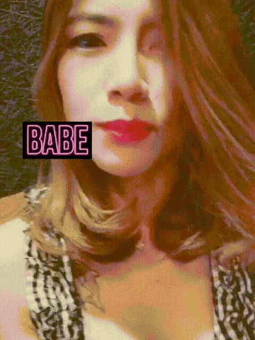 a woman 's face with a neon sign that says babe