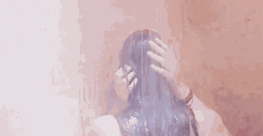 two women are taking a shower together and kissing each other .