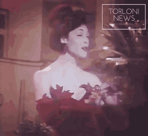 a woman is singing in front of a torloni news logo