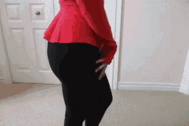 a woman in a red top and black pants is dancing