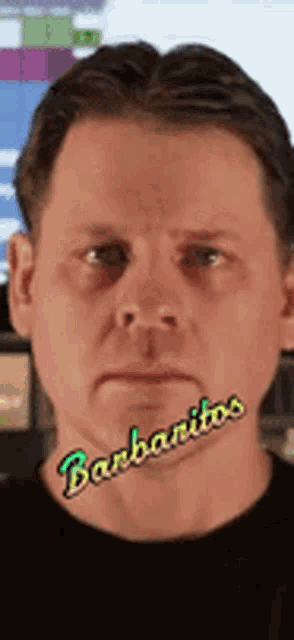a man with barbanitos on his face looks at the camera