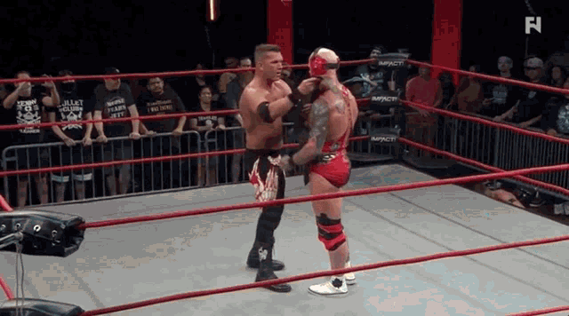 two wrestlers in a ring with the letter n on the bottom right