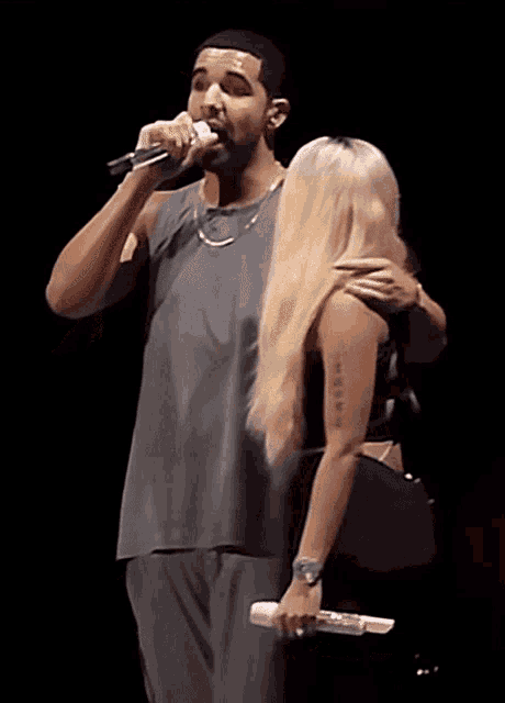 a man singing into a microphone while a woman holds a microphone