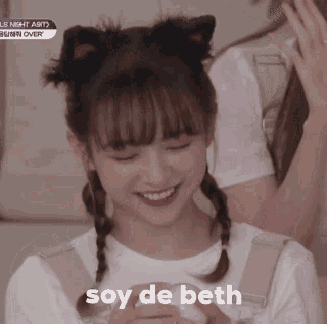 a girl with pigtails and cat ears is smiling and the words soy de beth are next to her