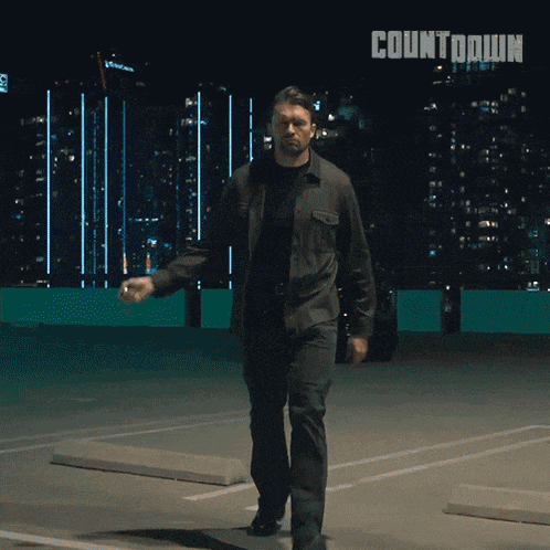 a man is walking in a parking lot with the word countdown on the bottom
