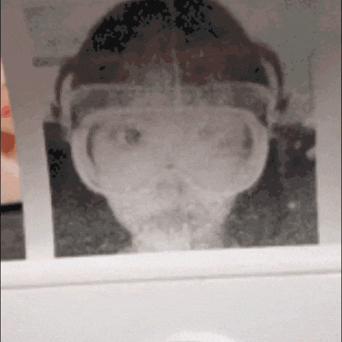 a black and white photo of a person 's face with headphones