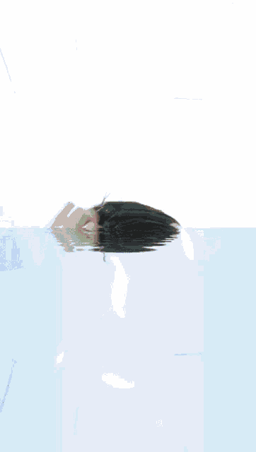 a person 's head is floating in the water with their hands