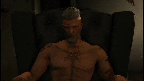 a shirtless man with a tattoo on his chest is sitting in a chair .
