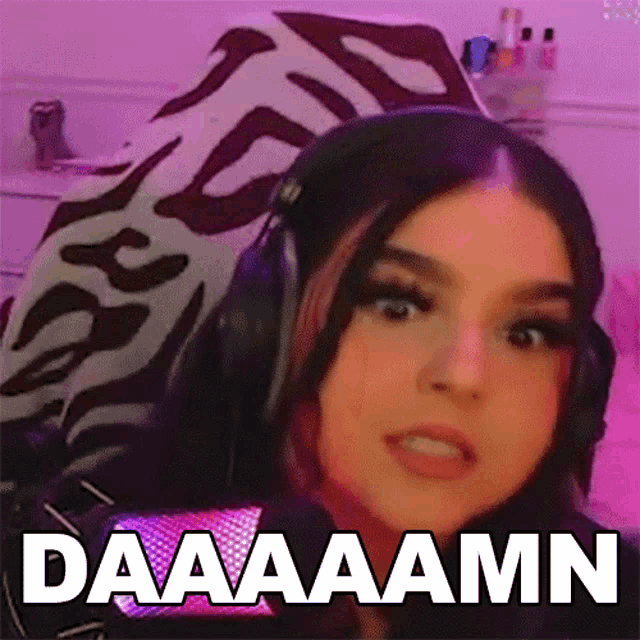 a woman wearing headphones says daaaaamn in front of her