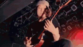 a man is playing a guitar on a stage .