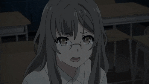 a girl wearing glasses is crying in a classroom