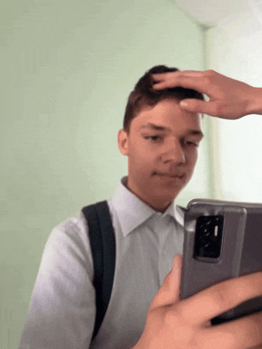 a young man taking a picture of himself with a cell phone