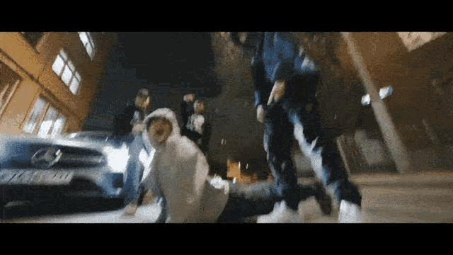 a group of people are standing in front of a car with a license plate that starts with the letter t