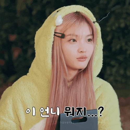 a girl with pink hair is wearing a yellow hoodie with a flower in her hair