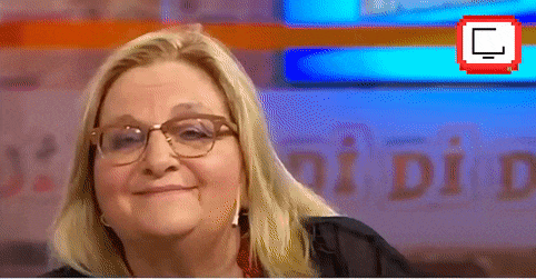 a woman wearing glasses is smiling in front of a sign that says " did "
