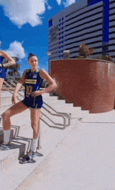 a volleyball player is standing on a set of stairs in front of a building .
